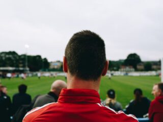 Man standing while watching soccer