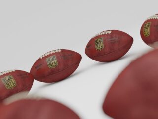 Several footballs on a white surfaceDescription automatically generated